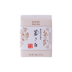 New unopened beige box of Ippodo Tea Co. Wakaki matcha with Japanese characters and gold leaf flowers embossed on white