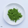 Bright green loose Japanese Ippodo Tea Kan matcha powder on white plate on white table