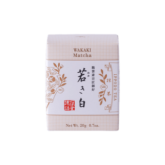 New unopened beige box of Ippodo Tea Co. Wakaki matcha with Japanese characters and gold leaf flowers embossed on white