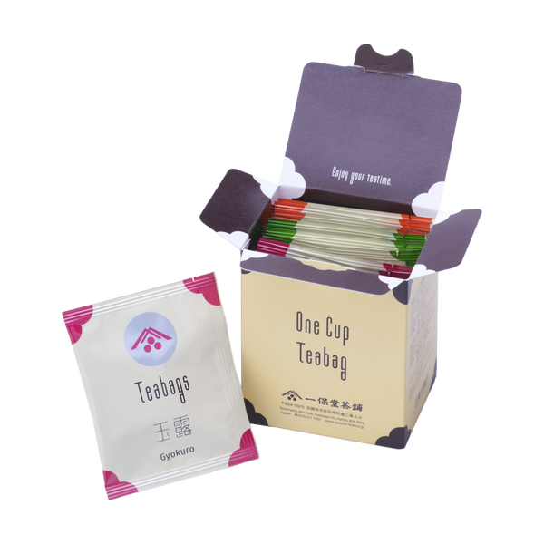 Open box of Ippodo One Cup Teabag packets with an individual gyokuro tea bag packet in front on a white background.