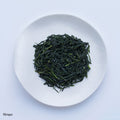 Ippodo Tea Rimpo gyokuro sample depicting loose dark blue green rolled futsumushi tea leaves on white plate on white table 