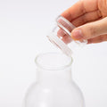 Opening glass lid of Ippodo glass carafe and displaying spill proof white silicone baffles used for water tight seal
