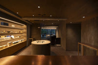 Front of of Ippodo Tea's flagship store, tearoom and headquarters black storefront in Kyoto, Japan with outdoor lit neon sign