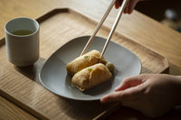 Front of of Ippodo Tea's flagship store, tearoom and headquarters black storefront in Kyoto, Japan with outdoor lit neon sign