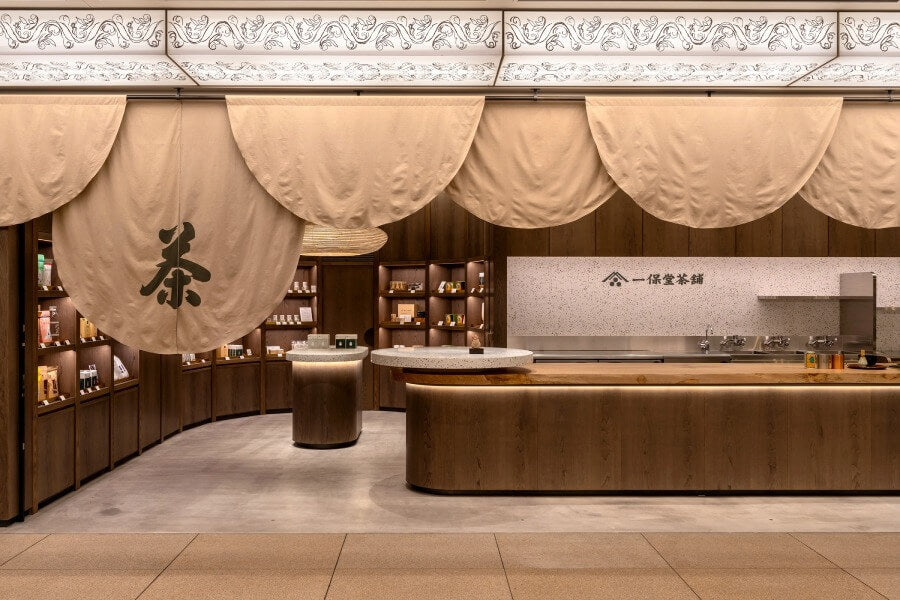 Black and white modern Tokyo storefront of Ippodo Tea's store and tearoom with warm lighting and large stone platform entry